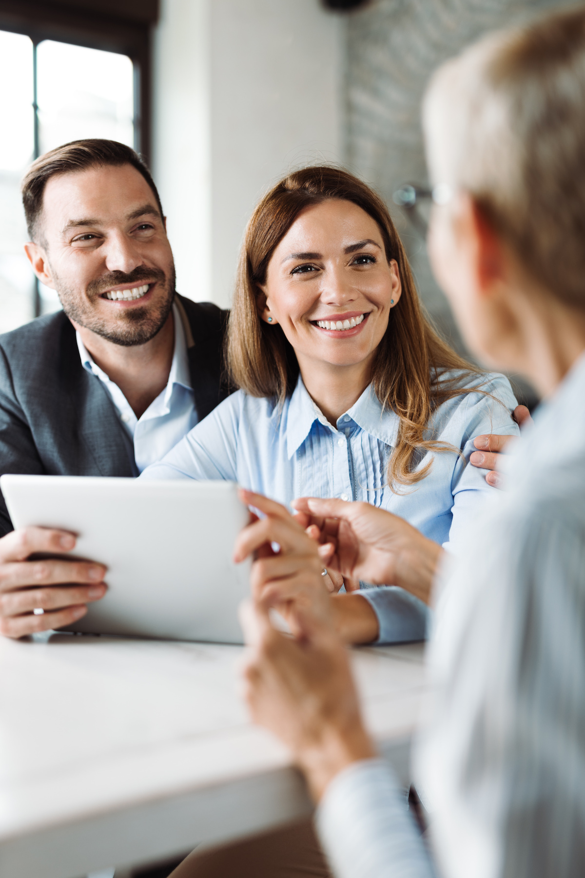 Happy couple talking with insurance agent on a meeting Calgary estate lawyer
